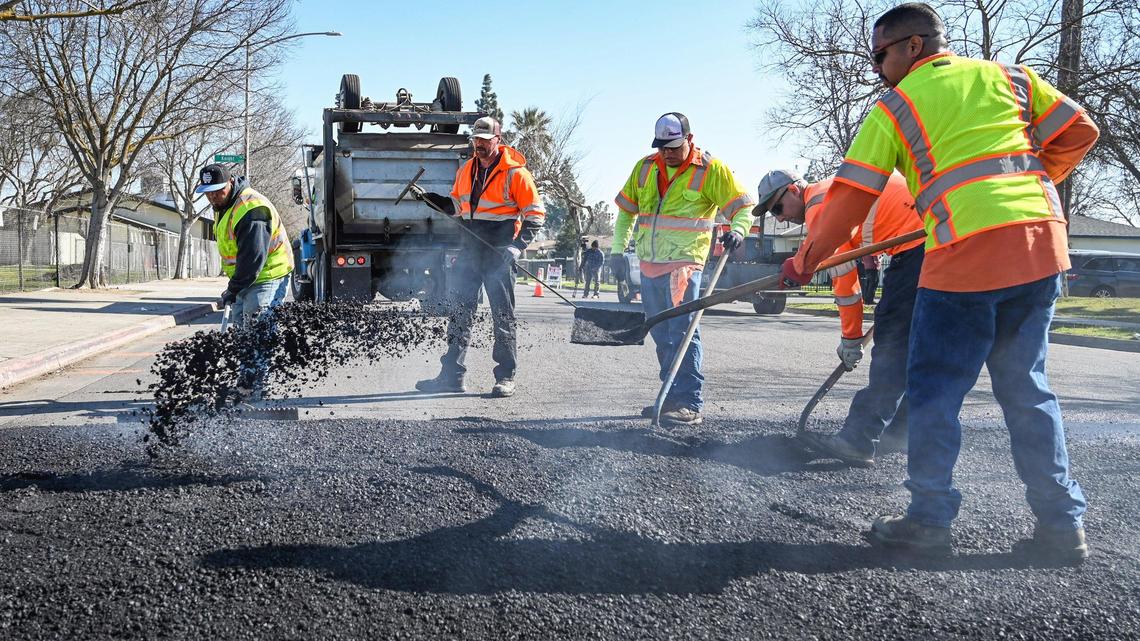 Fresno city work crews work to install a speed bump on Belgravia Avenue near Computech Middle School in Fresno on Monday, Feb. 7.