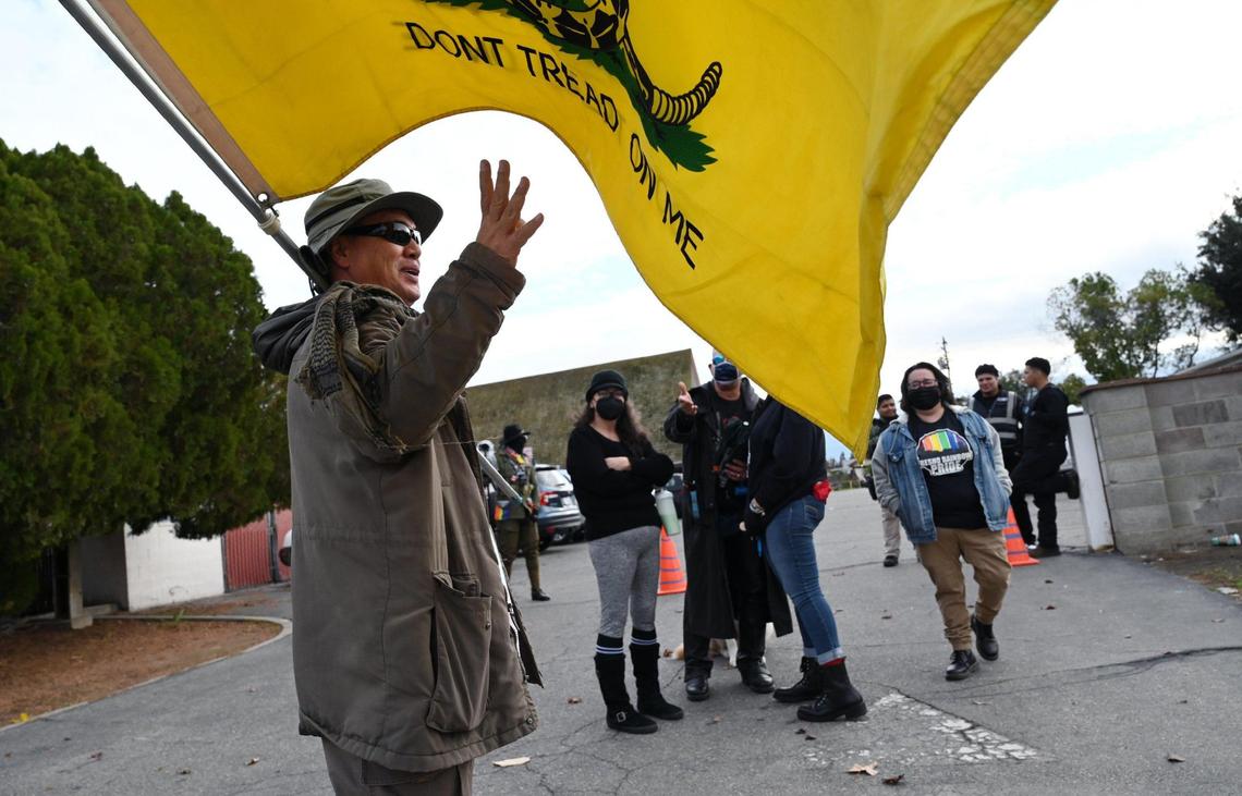 A protester holding a Do Not Tread On Me flag stands at the end of a driveway while the Fresno Drag Fest is held at Our Saviour’s Lutheran Church on Saturday, Dec. 10, 2022 in Fresno.