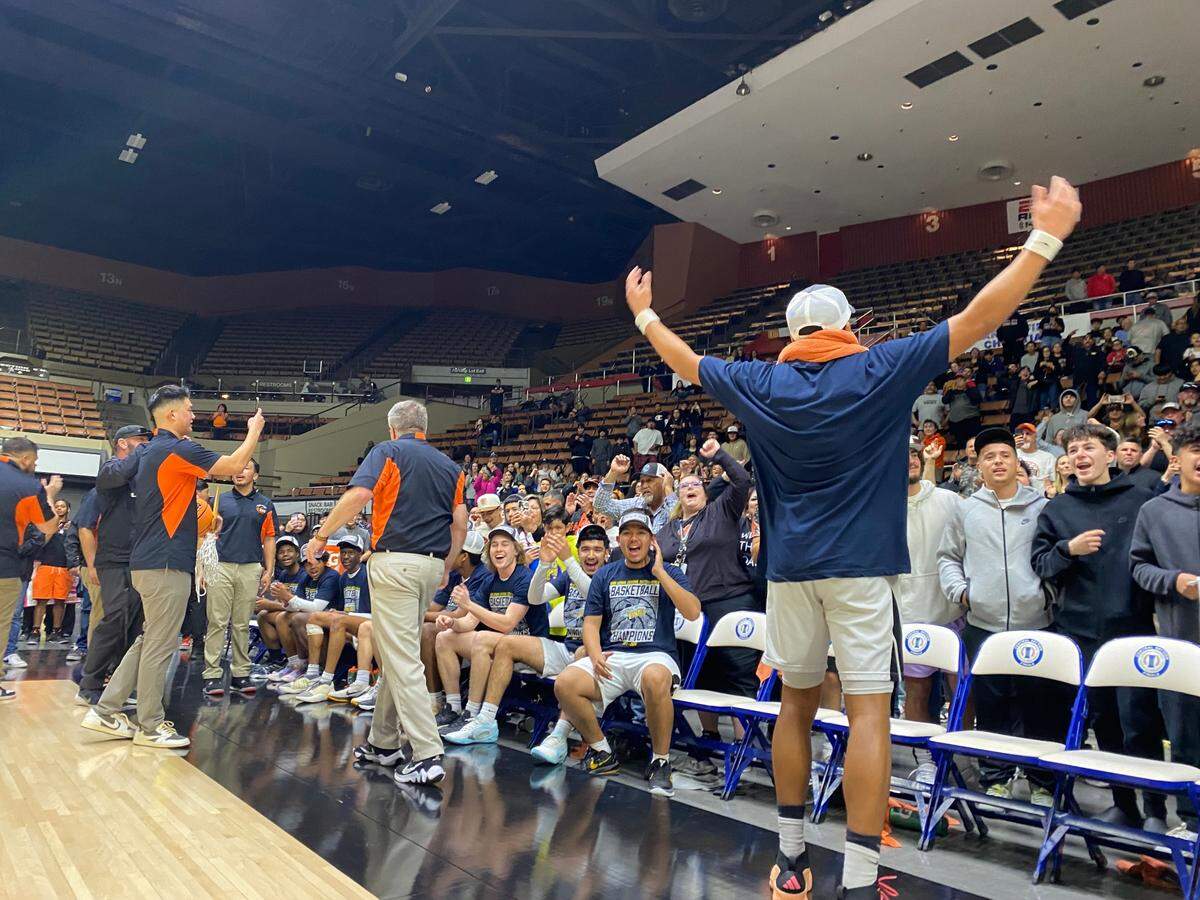 The Coalinga High basketball team celebrates a Central Section Division V title at Selland Arena in Fresno, California on Saturday, Feb. 24, 2024.