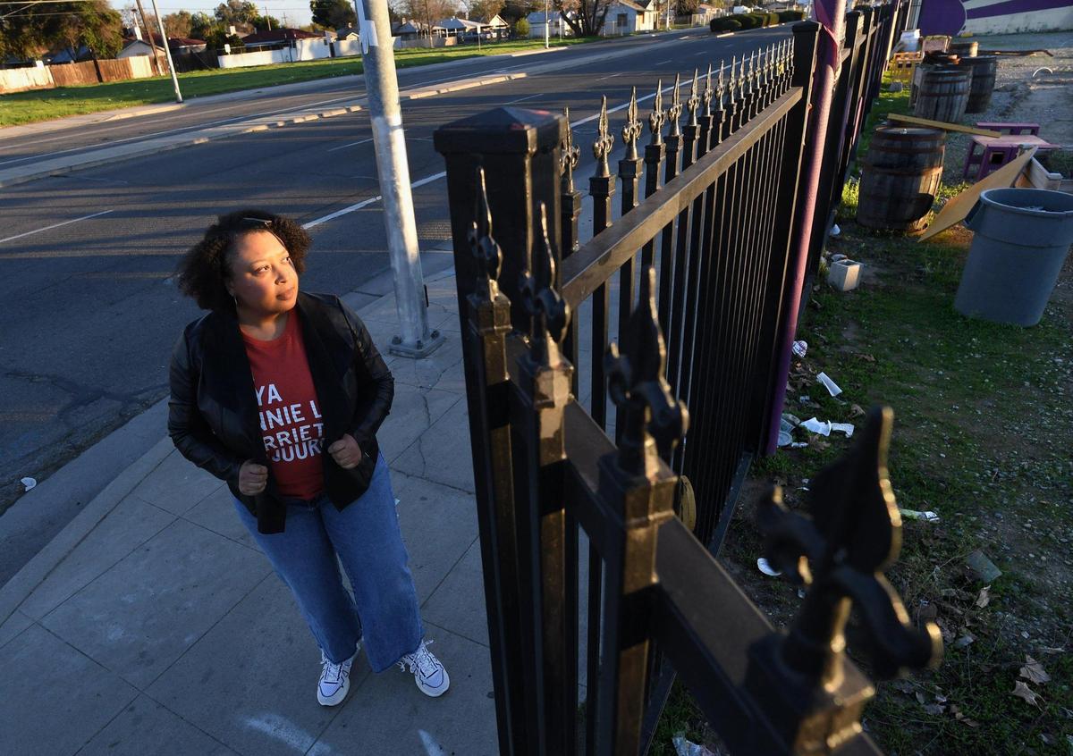Cherella Nicholson, Program Officer for Central Valley Community Foundation, stands at a brownfield site, at Elm Avenue and Reverend Chester Riggins Avenue, Feb. 4, 2021. The ground there is contaminated by a gas station located there decades ago. Though the site has been rehabbed into an outdoors community center, Saint Rest Plaza, development would be hindered by ground contamination.