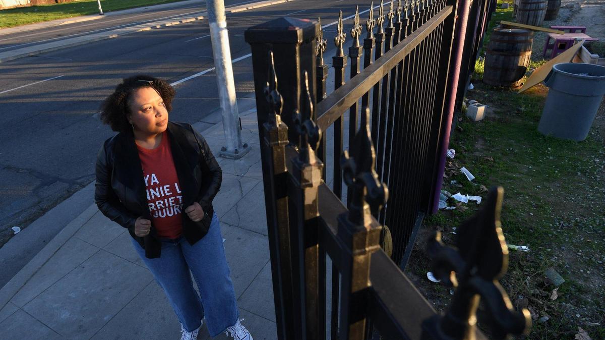 Cherella Nicholson, Program Officer for Central Valley Community Foundation, stands at a brownfield site, at Elm Avenue and Reverend Chester Riggins Avenue, Feb. 4, 2021. The ground there is contaminated by a gas station located there decades ago. Though the site has been rehabbed into an outdoors community center, Saint Rest Plaza, development would be hindered by ground contamination.