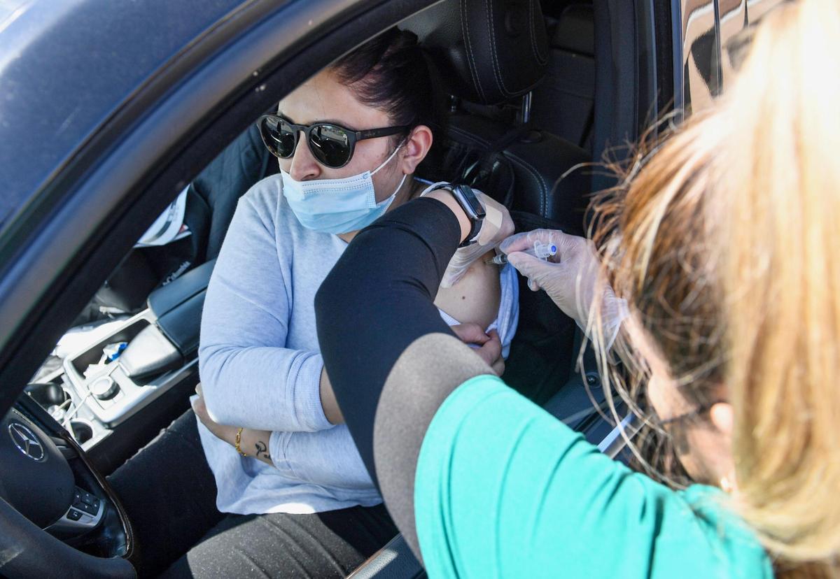 Rupinder Kaur of Selma has her Johnson & Johnson COVID-19 vaccination shot administered by nurse Ashley Guzman during a drive-up vaccination and resource fair for over 1000 Punjabi food and agriculture workers at the Sikh Center of the Pacific Coast Gurdwara in Selma, on Saturday, March 27, 2021.