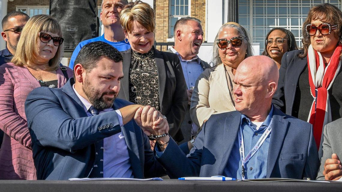 Fresno Teachers Association President Manuel Bonilla, left, and Fresno Unified School District Superintendent Bob Nelson shake hands after signing a contract agreement between the district and the Fresno Teachers Association with members of both organizations and in front of students at Fresno High School on Tuesday, Oct. 31, 2023. The move avoids a strike that was to commence on Wednesday.