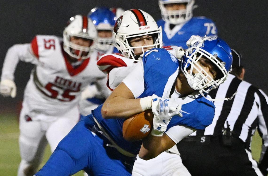Kerman’s Elijah Chalabian, center, tackles Madera’s Jayden Martinez, right, in the Central Section DIII championship held Friday, Nov. 29, 2024 in Madera.