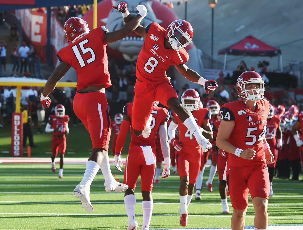 Tight end Cam Sutton, left, and wide receiver Chris Coleman, right, take to the air as the Fresno State Bulldogs take the field against Colorado State on Saturday.