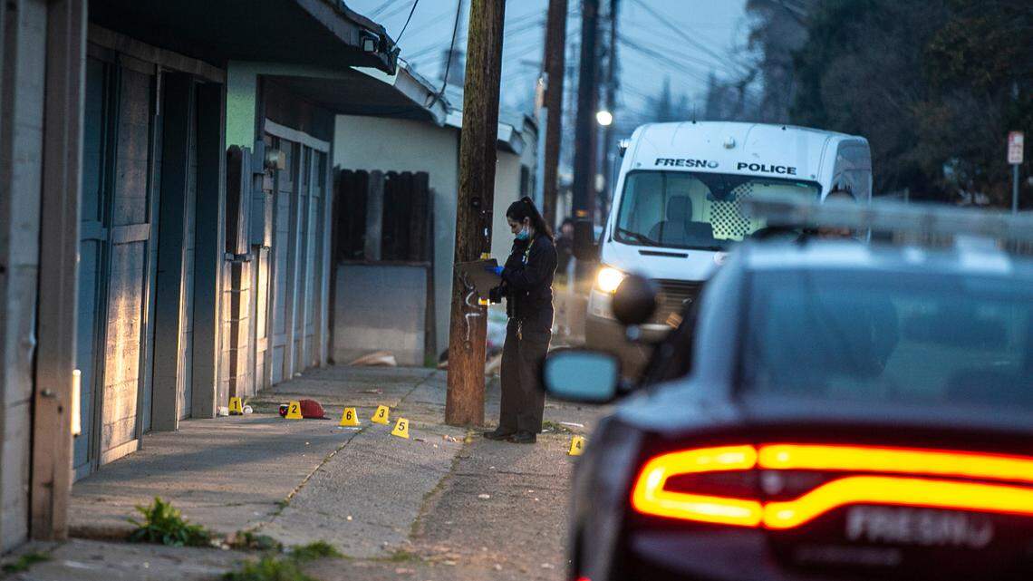 A Crime Scene Investigator sorts out evidence at a crime scene where a police officer was attacked by a suspect near Clinton Avenue and First Street on Friday, Jan. 14, 2022.