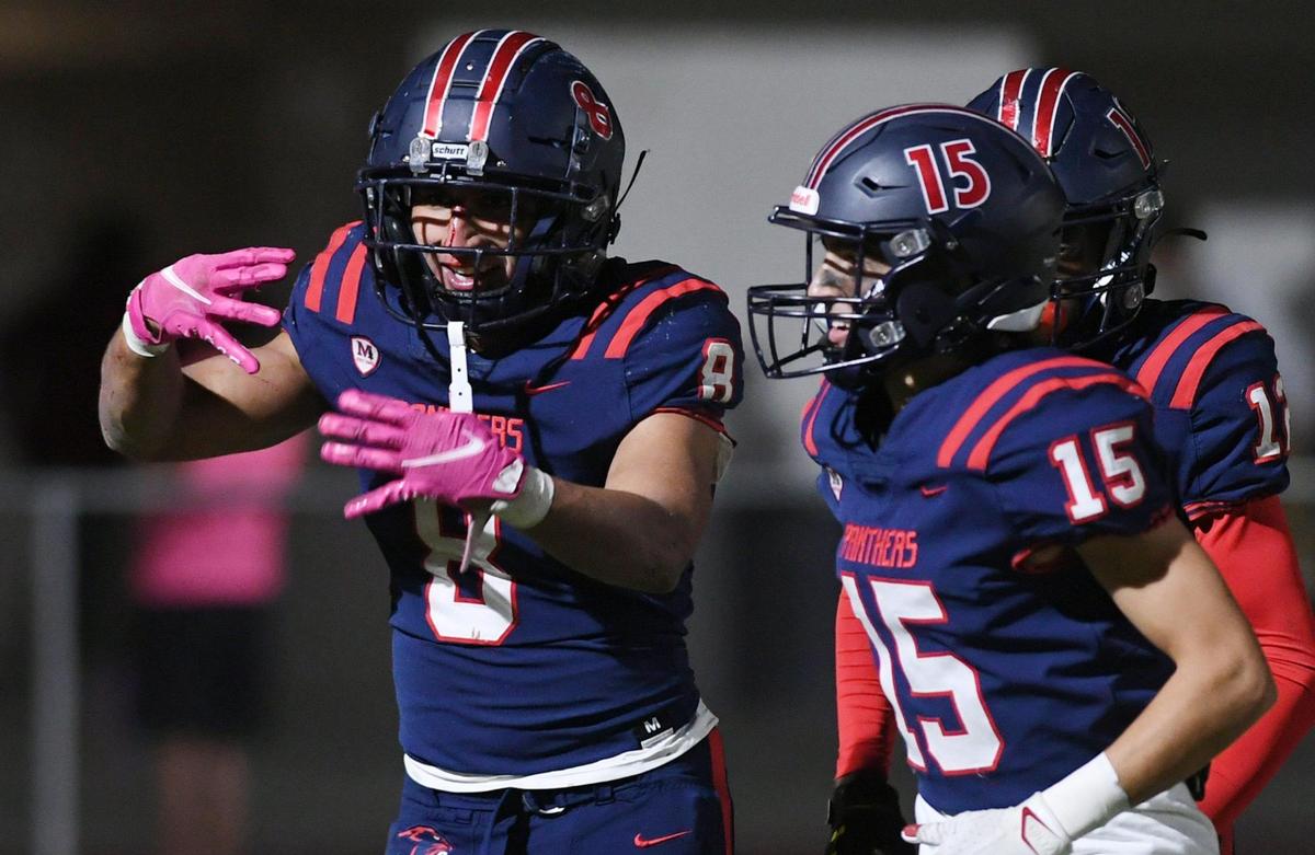 San Joaquin Memorial’s Brandon Ramirez hold up four fingers on each hand to show four CMAC wins in five years in the game against Sanger Friday, Oct. 28, 2022 in Fresno. Memorial dominated Sanger to a 56-21 championship win in the County/Metro Athletic Conference.