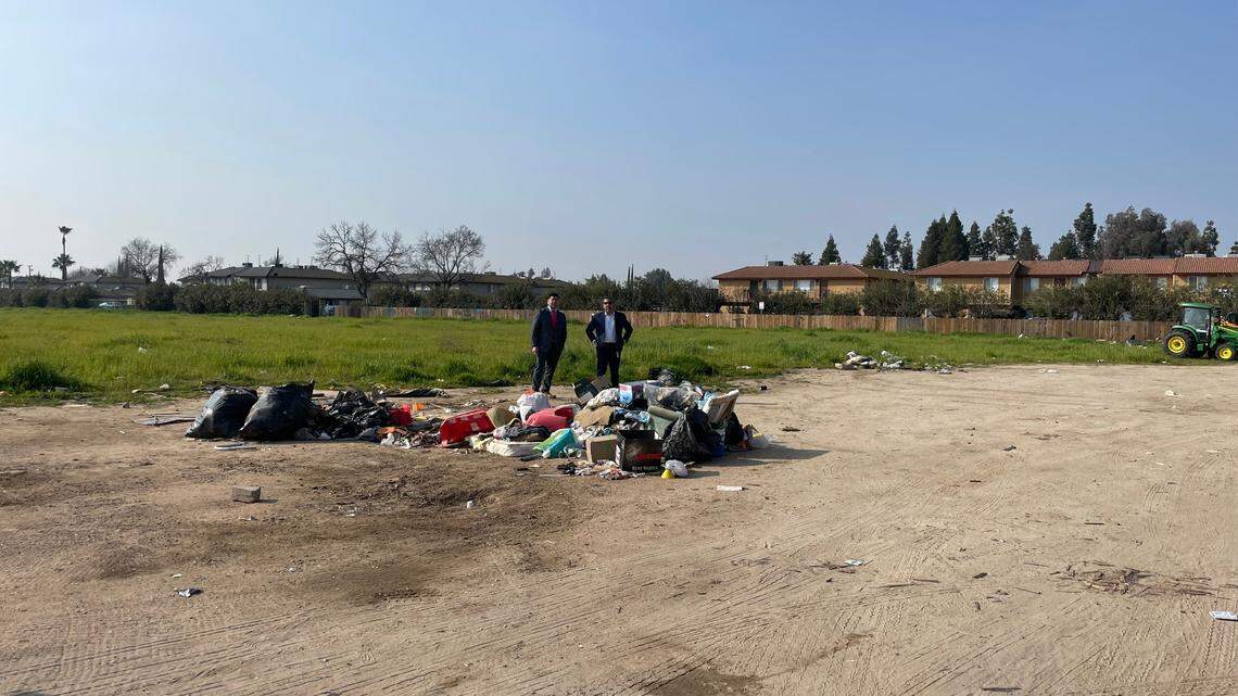 Fresno City Councilmembers Luis Chavez and Miguel Arias stand in a vacant lot near North Marks and West Shields avenues where code enforcement has cleaned up illegal dumping.