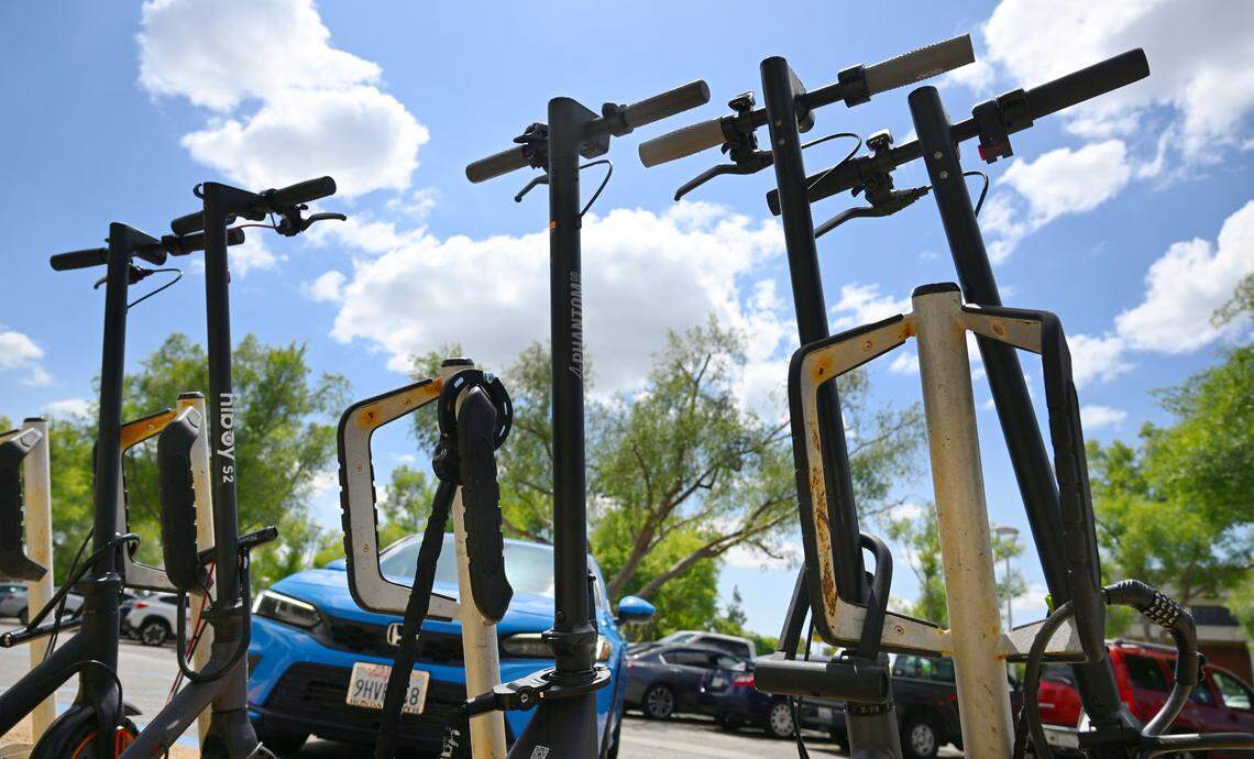 Motorized scooters are seen locked outside Fresno State's Lynda and Stewart Resnick Student Union Monday, April 27, 2026 in Fresno. Fresno State will begin a ban on all motorized scooters, skate boards and bikes starting August 19 this year.