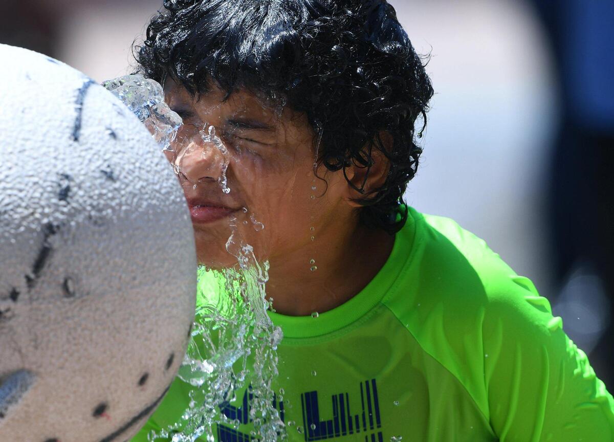 Brandon Colbert, 9, keeps cool at Fig Garden Loop Park as his family gathers to celebrate a birthday Saturday, July 10, 2021 in Fresno, California. The National Weather Service issued an excessive heat warning through 9 p.m. Monday, with a high near 111 expected Saturday afternoon and near 113 Sunday.