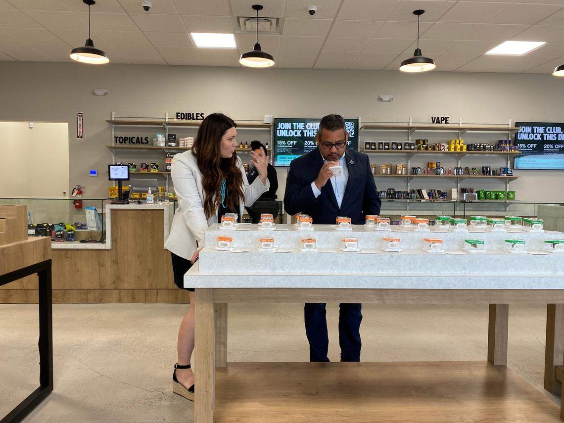 Fresno Councilmember Miguel Arias smells cannabis flower while talking to store owner Lauren Carpenter, on Monday July 11, 2022, at Embarc, the first cannabis store to open in the city.