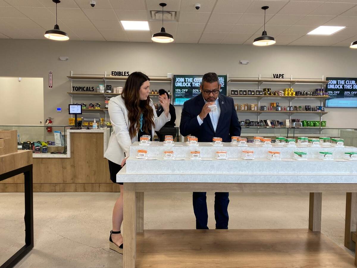 Fresno Councilmember Miguel Arias smells cannabis flower while talking to store owner Lauren Carpenter, on Monday July 11, 2022, at Embarc, the first cannabis store to open in the city.