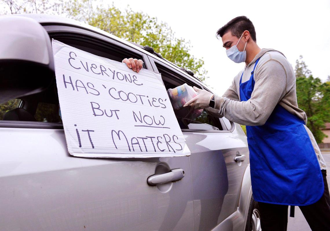 Austin Yniguez, a childhood friend of San Joaquin Memorial graduate and University of California, Berkeley’s Zach Angelillo, helps distribute food at a giveaway held at University Presbyterian Church of Fresno Saturday morning, April 18, 2020 in Fresno.