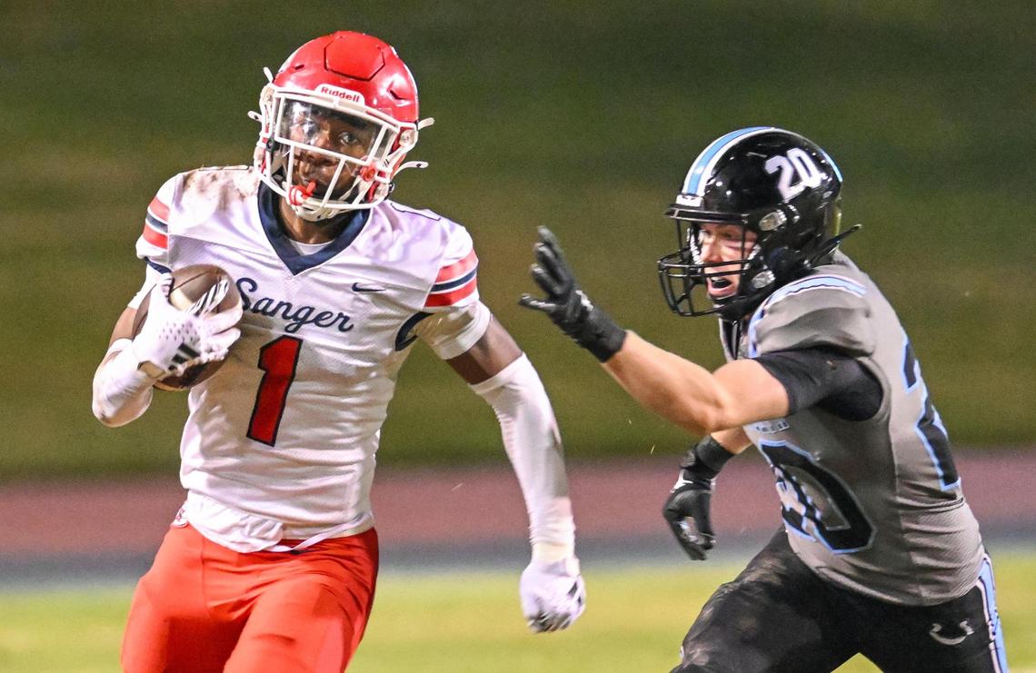 Sanger’s Bryson Baker takes the ball around the end as Clovis North’s reaches for him in hot pursuit during their Division I-AA quarterfinal playoff game at Veterans Memorial Stadium in Clovis on Friday, Nov. 8, 2024.