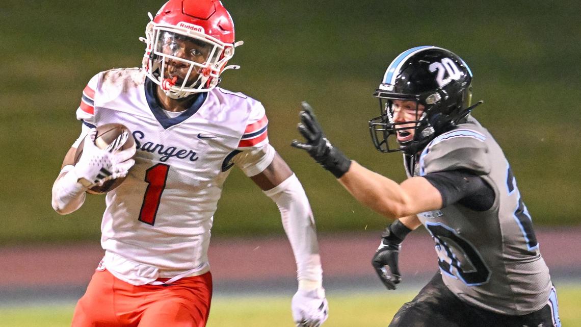 Sanger’s Bryson Baker takes the ball around the end as Clovis North’s reaches for him in hot pursuit during their Division I-AA quarterfinal playoff game at Veterans Memorial Stadium in Clovis on Friday, Nov. 8, 2024.