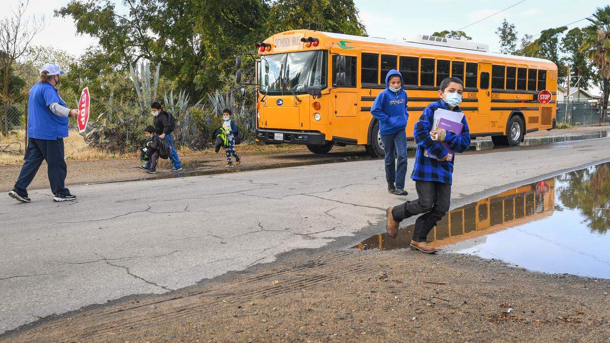 Kids unload from a West Park School District school bus south west of Fresno on Monday, Oct. 25, 2021. Rural roads in Fresno County are neglected due to a county decision to not maintain them. That means potholes, flooding and basic safety measures go unfixed.