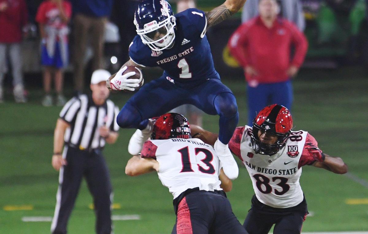 Fresno State’s Nikko Remigio, top, leaps over San Diego State’sJack Browning, bottom, Saturday, Oct. 29, 2022 in Fresno.