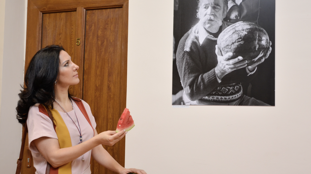Anush Aslibekian-Artsruni, an Armenian citizen whose doctorate thesis is on Fresno author William Saroyan, holds a piece of watermelon next to a photo of him. “The biggest watermelon anybody ever saw” is a story written by Saryoan.