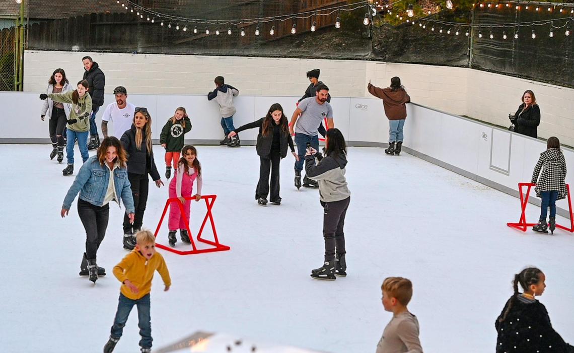 Visitors glide around on the new synthetic skate rink at The Pines Resort on Bass Lake on Wednesday, Dec. 28, 2022. The rink is a new wintertime amenity at the resort and has two sessions a day.