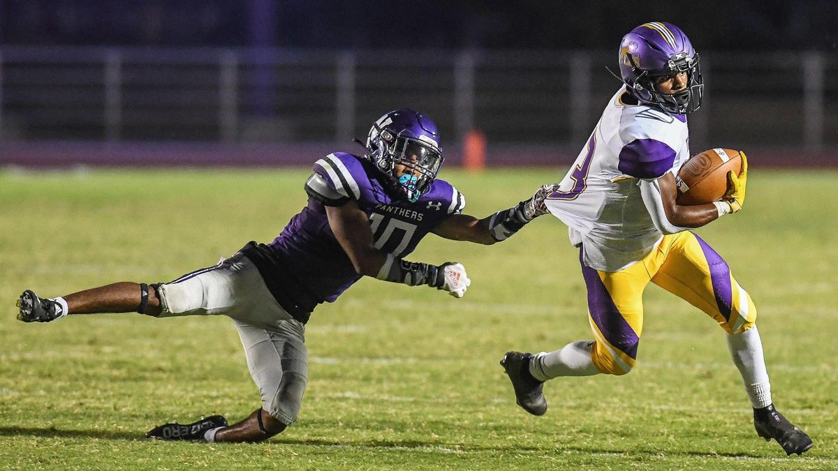 Lemoore’s Cory Whitmore, right, tries to turn the corner as Washington Union’s Noah Taylor snags his jersey from behind in their game at Washington Union on Friday, Aug. 26, 2022.
