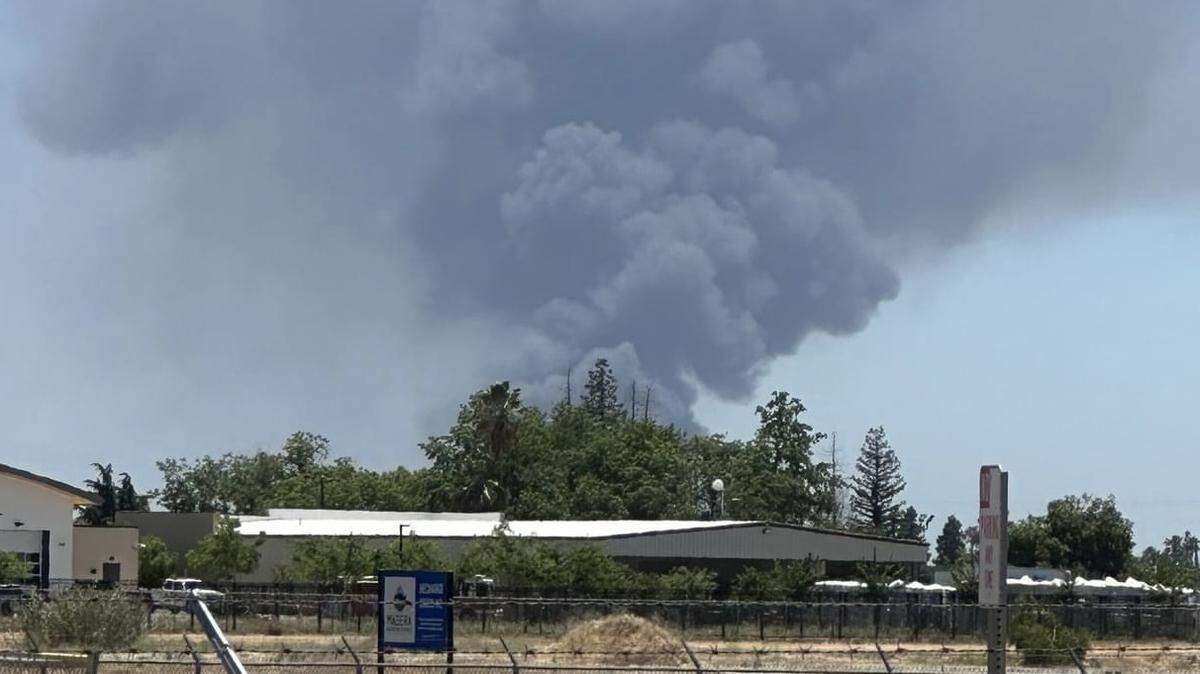 Black smoke rises after a fire broke out at a wrecking yard in Madera, California on Friday, June 14, 2024.