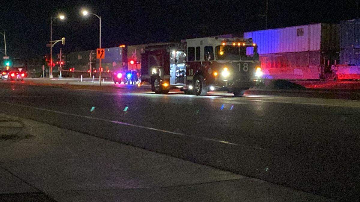 Emergency workers treat a man who was struck by a train in northwest Fresno on July 15.