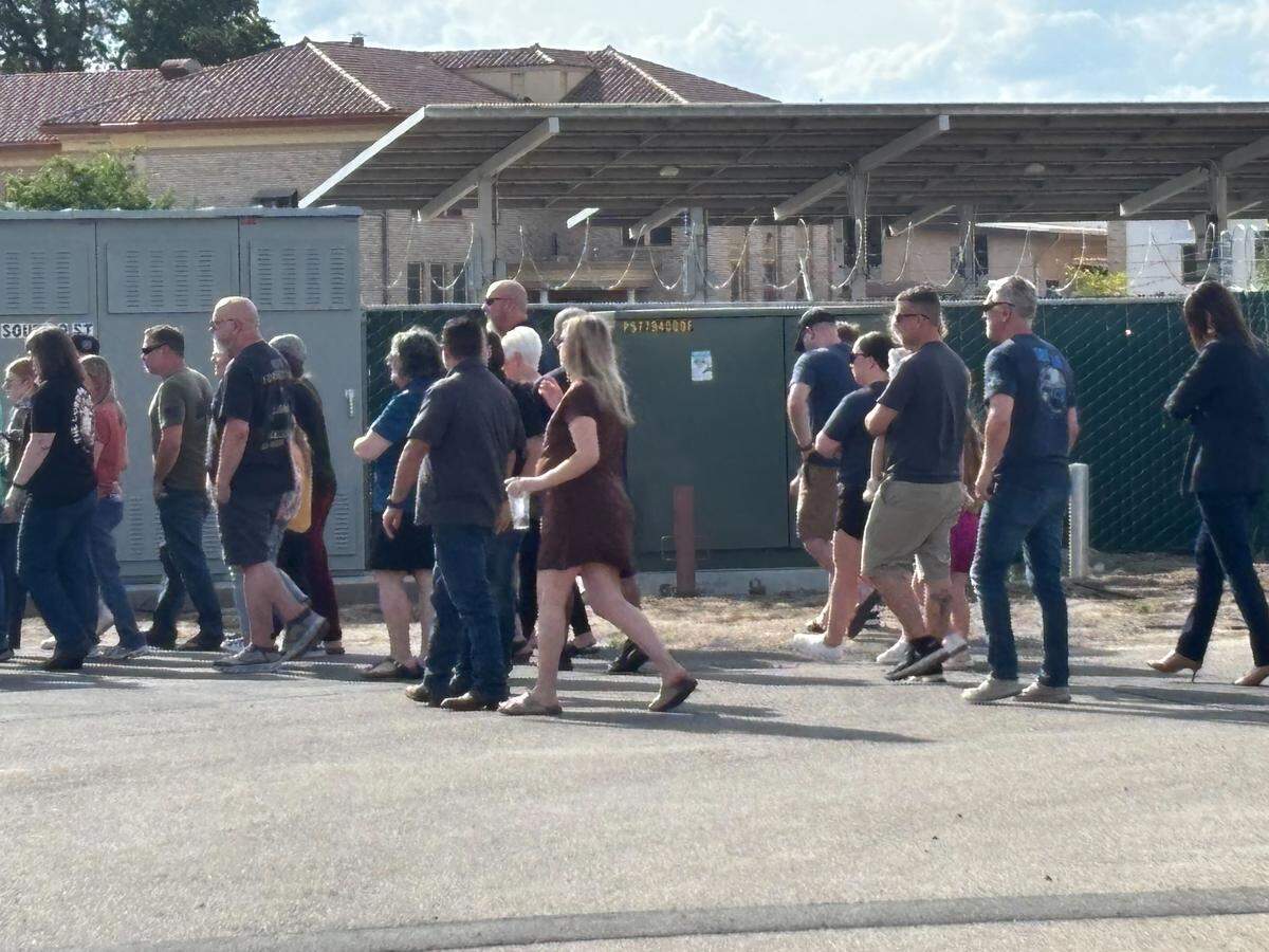 Community members and emergency personnel receive the body of a slain deputy at the Tulare County Coroner’s office in Tulare, California on Thursday, April 9, 2026.