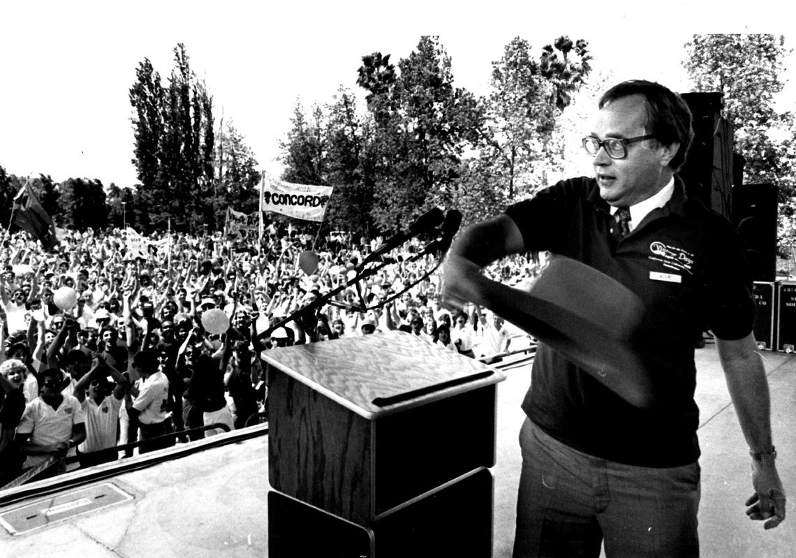 Fresno State President Harold Haak tosses a hat over the crowd to open a Vintage days celebration at the Amphitheater.