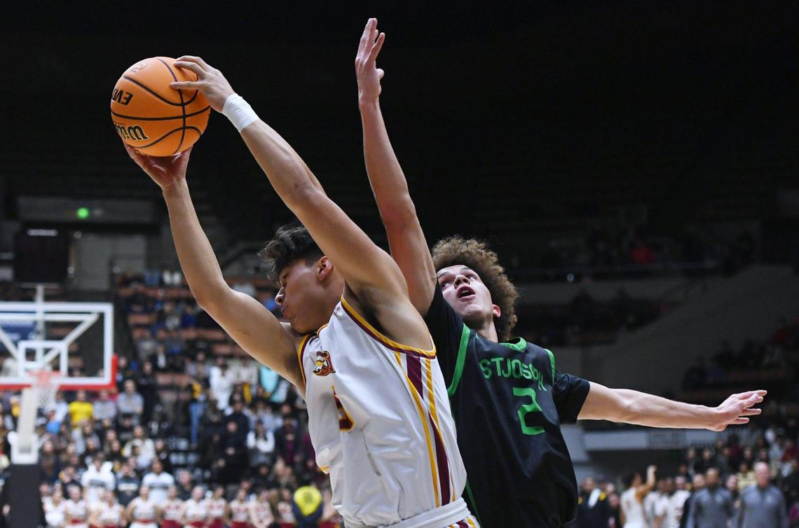 Clovis West’s Tytus Khajavi, left, grabs the rebound with St. Joseph’s Luis Marin to the right in the Central Section boys Division I basketball championship Saturday, Feb. 25, 2023 in Fresno.