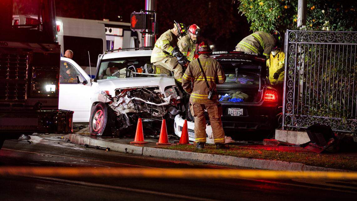 Fresno firefighters work to remove the roof of a police vehicle involved in a traffic collision at the intersection of Tulare and R streets on Thursday, Dec. 9, 2021. 