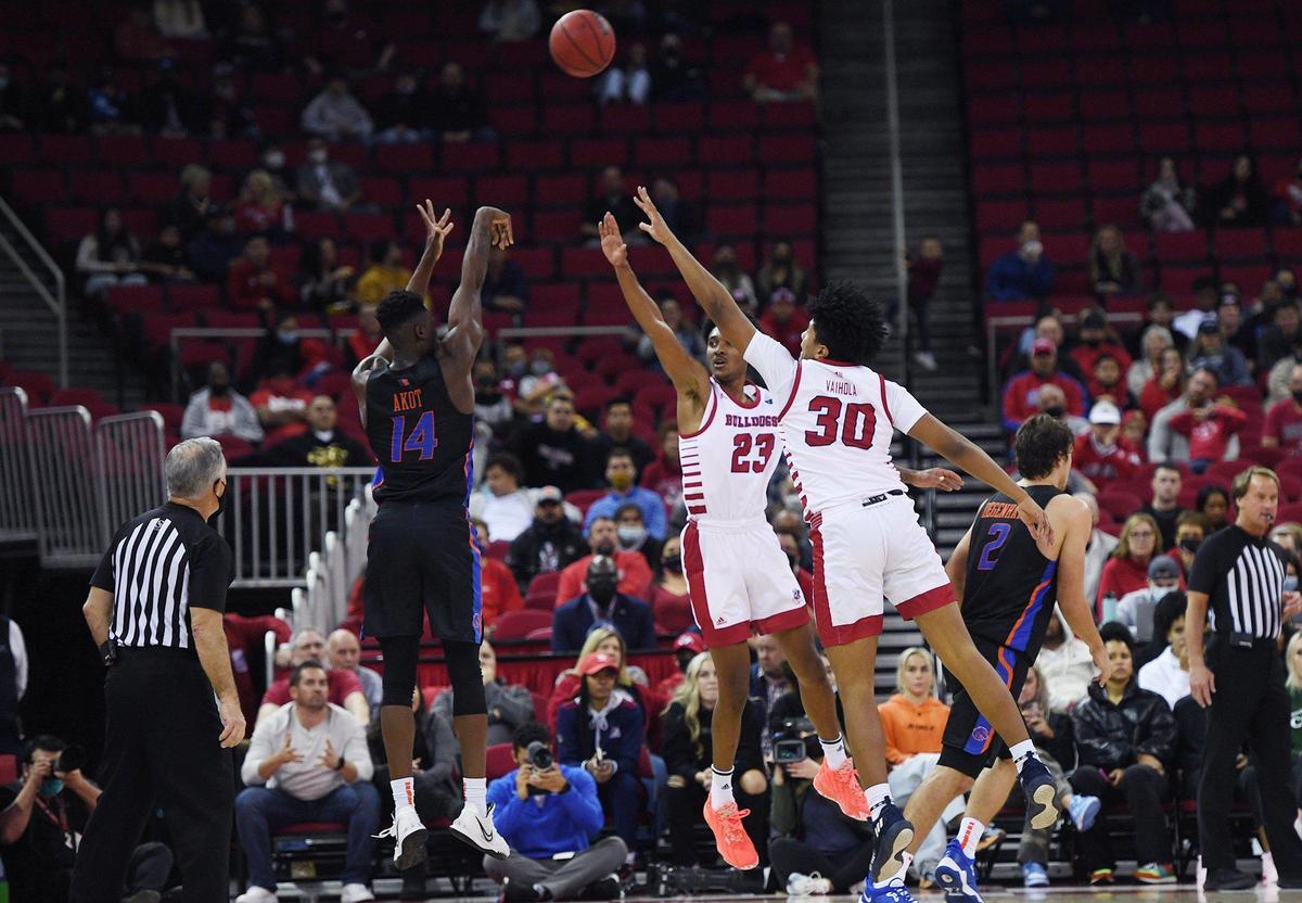 Boise State’s Emmanuel Akot, left, shoots with Fresno State’s Leo Colimerio, center, and Robert Vaihola, right, Friday, Jan. 28, 2022 in Fresno.
