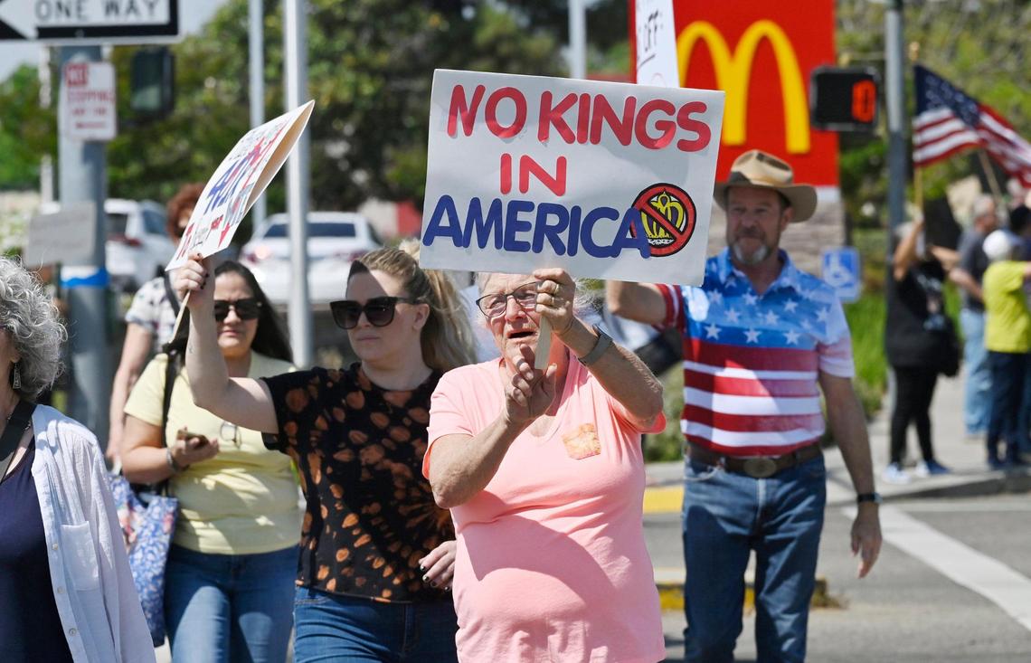 A group crosses Clovis Avenue as an estimated 400 or more of all ages gathered at the corner of Shaw and Clovis avenues for a Hands Off rally with the theme No Kings Saturday, April 19, 2025 in Clovis.