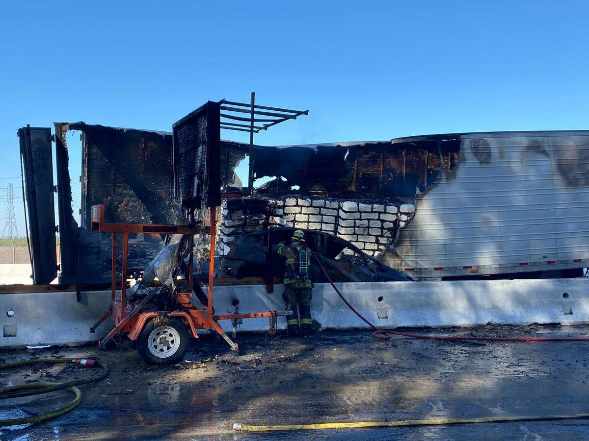 A firefighter checks for hot spots in a big rig trailer after a fiery crash on northbound Highway 99 between Selma and Fowler on Thursday morning, July 7, 2022.
