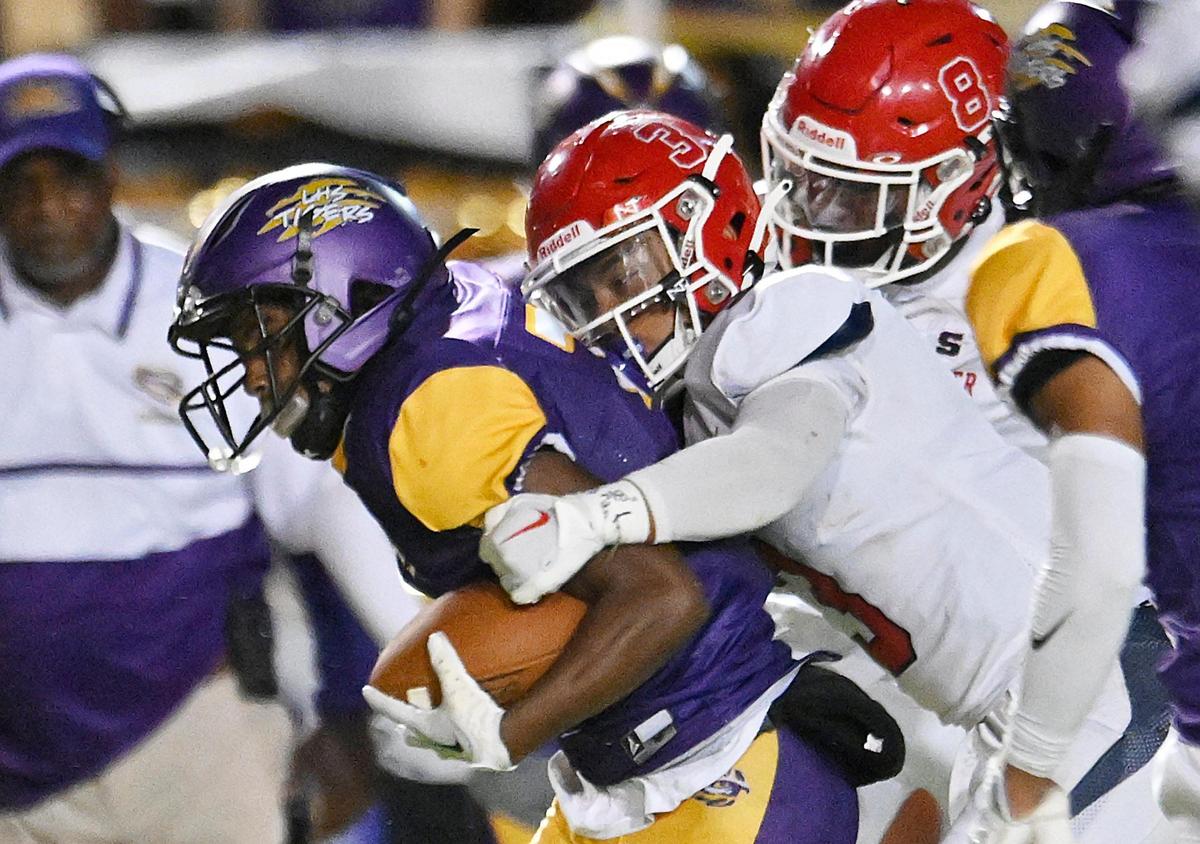 Sanger’s Jaden Chanthalangsy, center, and Bryson Baker, right, combine to tackle Lemoore’s Kobe Green, left, Friday, Sept. 8, 2023 in Lemoore. Sanger dominated Lemoore in the 42-13 win.