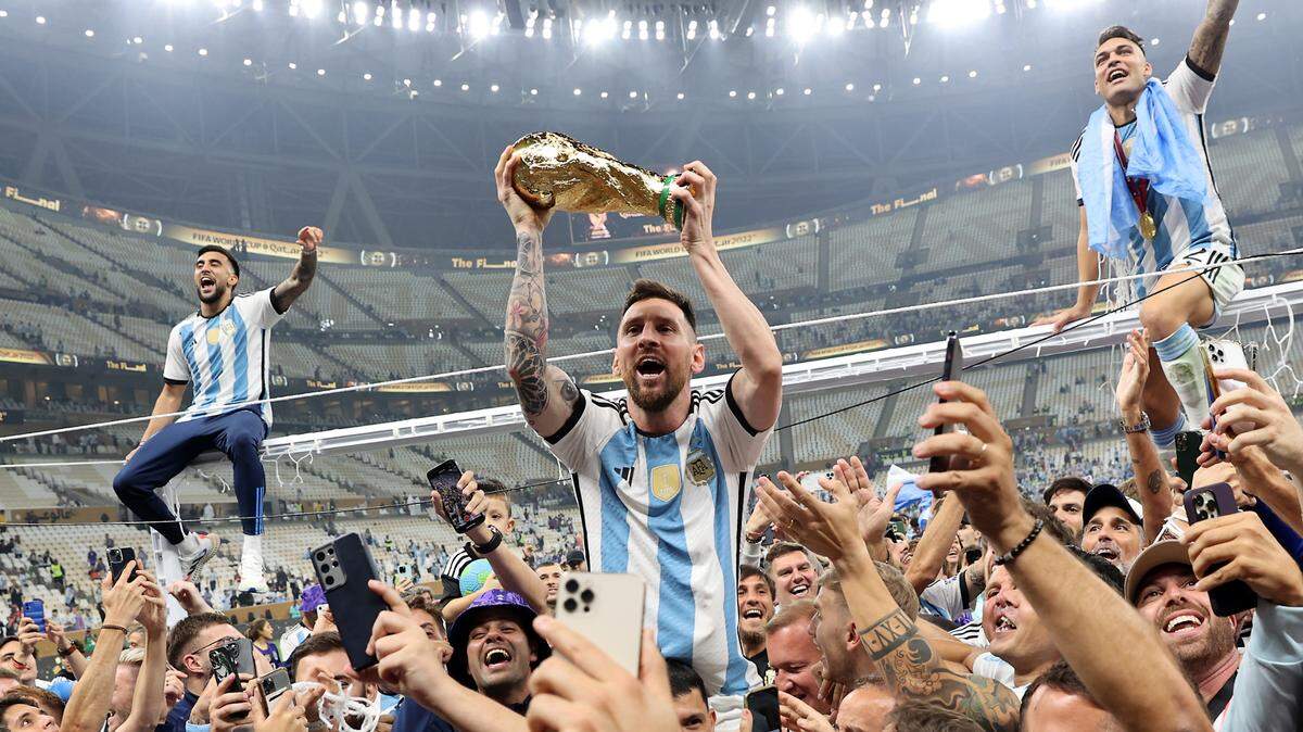 Lionel Messi (c) alza el trofeo del campeones del Mundial de Qatar 2022 después de que Argentina se impusiera a Francia en la final celebrada en el Lusail stadium, el 18 de diciembre.