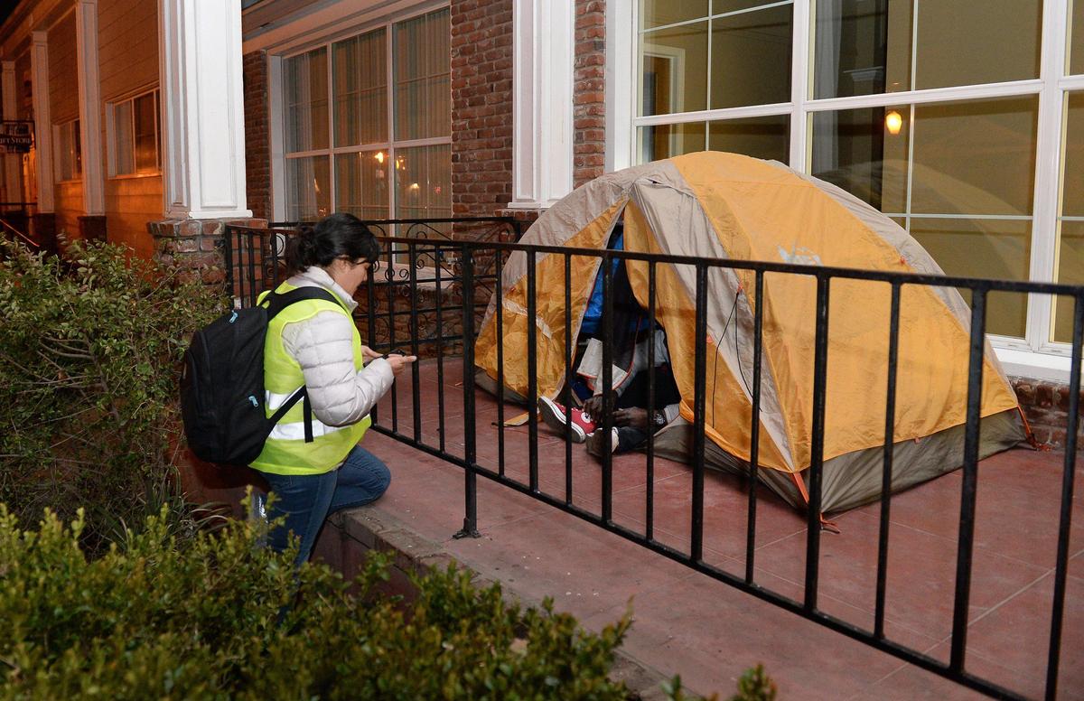 Homeless survey volunteer Aimee Bird gathers information from a homeless man living in a tent on the front step of Catholic Charities in Fresno during the Point-in-Time homeless count hosted by the Fresno Madera Continuum of Care, on Wednesday, Jan. 29, 2020.