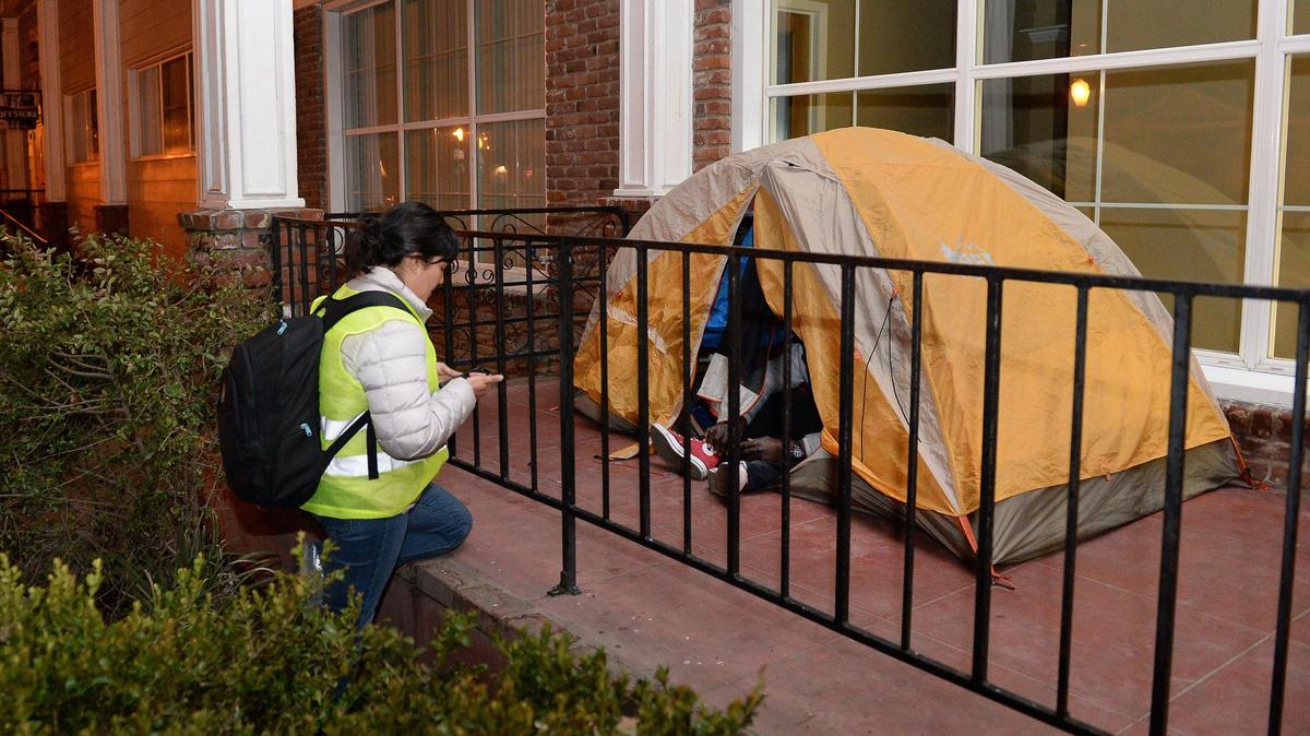 Homeless survey volunteer Aimee Bird gathers survey information from a homeless man living in a tent on the front step at Catholic Charities in Fresno during the Point-in-Time homeless count hosted by the Fresno Madera Continuum of Care, on Wednesday, Jan. 29, 2020.