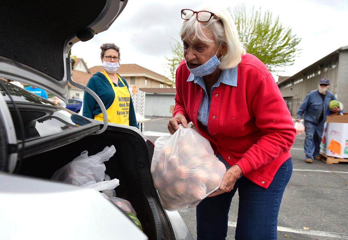 Volunteer Cheryl Phelps, right, helps load food at a food bank giveaway held at Easton Presbyterian Church Monday, April 6, 2020 in Easton.