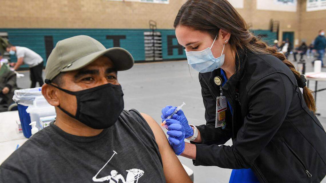 Fresno State nursing student Monique Lange administers a Moderna COVID-19 vaccination shot to Ricardo Andrade of Reedley during a Fresno County rural vaccine clinic at Orange Cove High School on Tuesday, March 16, 2021.