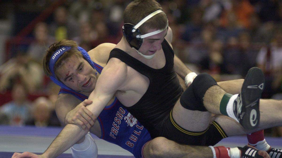 Fresno State’s Stephen Abas, left, grapples with Iowa’s Luke Eustice en route to winning the 2002 NCAA championship, Abas’ third. Abas, 41, was named Fresno High School wrestling coach on Friday, May 31, 2019.