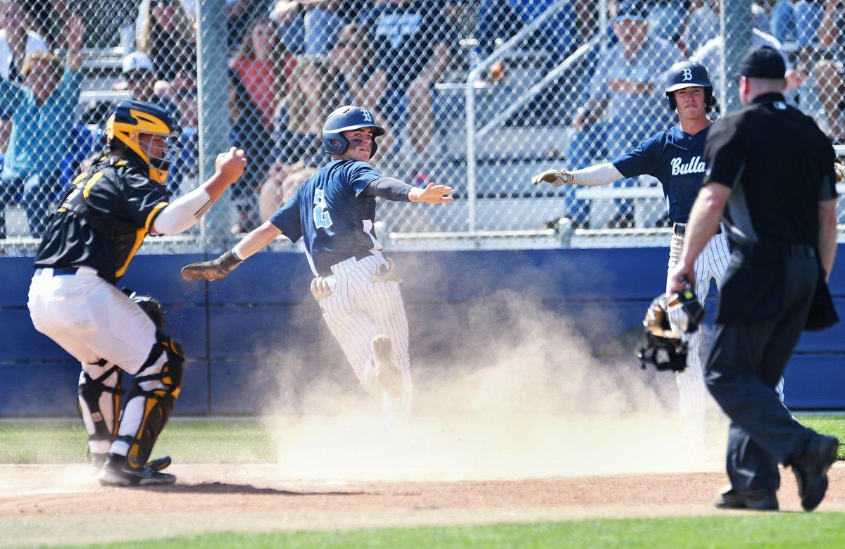 Bullard’s Beckett Zavorek, center, is safe after sliding to home plate as the Knights defeated the Edison Tigers 2-0 in a County/Metro Athletic Conference baseball game Saturday, March 26, 2022 in Fresno.