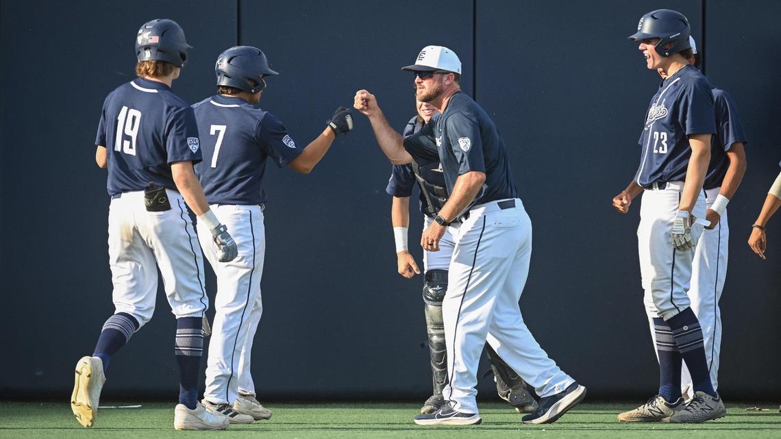 Clovis East coach Ryan Smith, center, congratulates Erik Perez, 7, and Brennan Johnson who scored the first two runs of their Central Section Division II baseball championship game against Central at Pete Beiden Field on Friday, May 27, 2022.