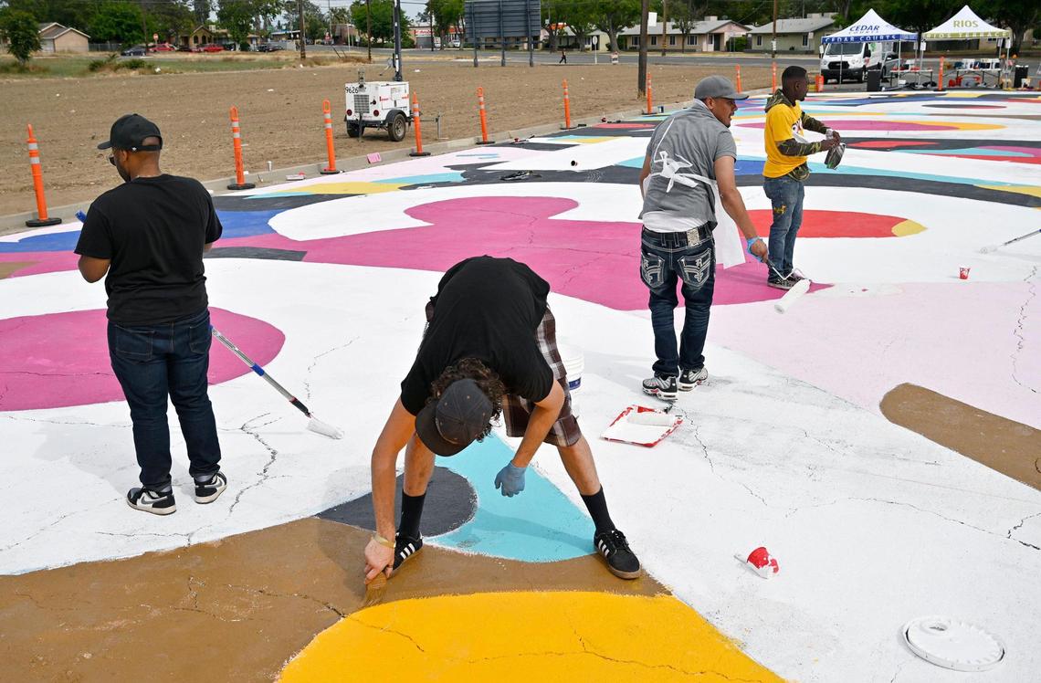 Volunteers and artists gathered to help paint a large “93706” street mural along Klette Avenue just north of California Avenue as part of the West Fresno California Avenue Neighborhood (CAN) initiative Saturday, May 6, 2023 in Fresno. Area residents and artists gathered to paint the permanent mural as part of a revitalization effort.