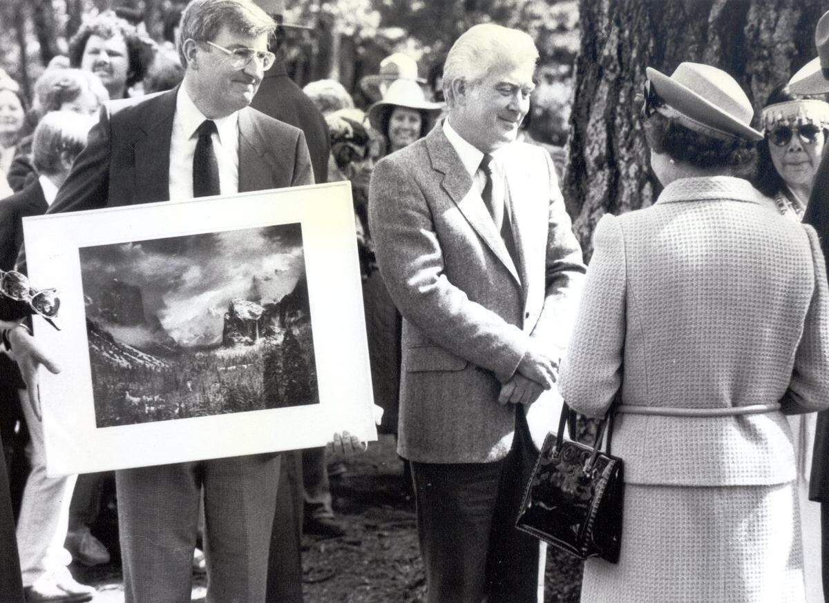 During her 1983 visit to Yosemite National Park, Queen Elizabeth II meets with Dr. Michael Adams, left, who presented her with a print by his father, Ansel Adams, and carver Rocky Reinhart.