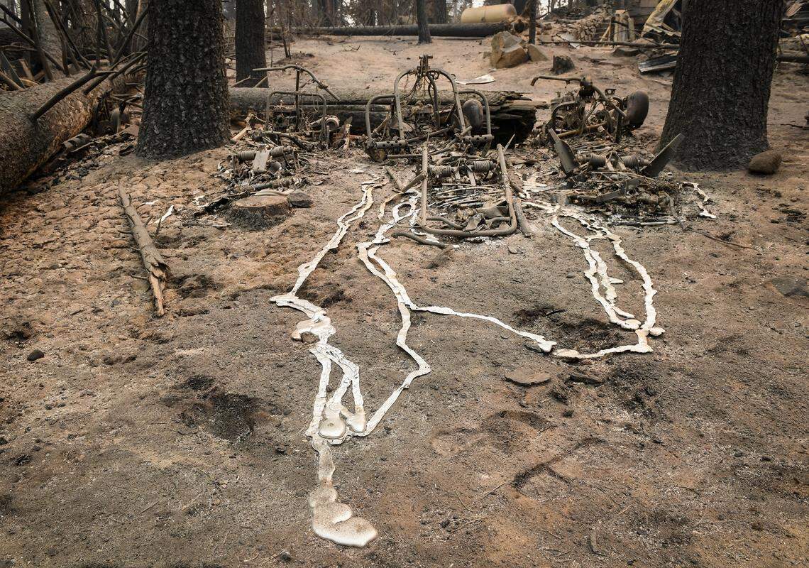 Melted metal is seen where is ran off of burned vehicles, possibly snow mobiles, outside a burned cabin in the Camp Silver Fir area on the north of Huntington Lake on Sunday, Sept. 13, 2020. Fire officials said a fire tornado blew through the area at some point last week burning cabins and knocking down many trees.