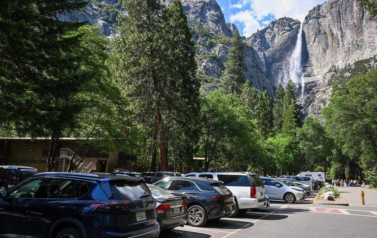 Cars fill the parking lot outside Yosemite Lodge on a busy day at Yosemite National Park on Thursday, May 22, 2026. The reservation system that previously limited traffic in the park was canceled this year.