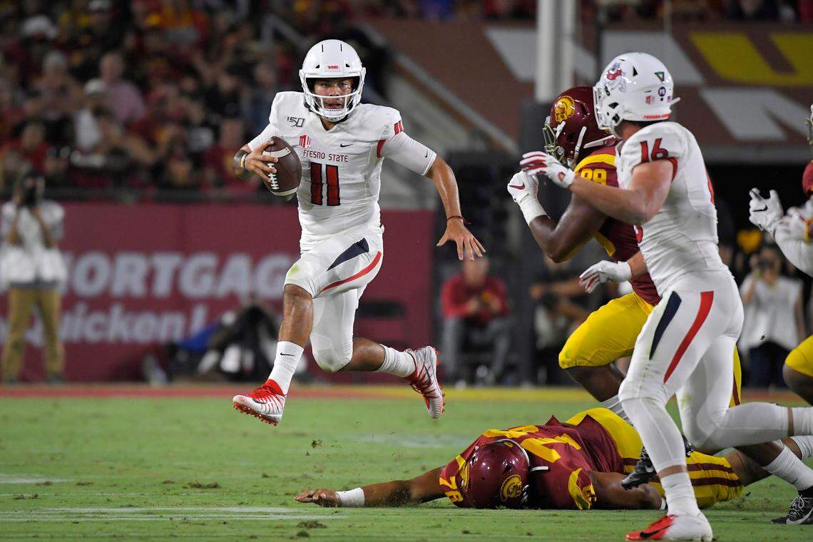 Fresno State quarterback Jorge Reyna, left, escapes a tackle by Southern California defensive lineman Jay Tufele, below, as defensive lineman Christian Rector, second from right, gives chase and tight end Jared Rice runs in during the first half of an NCAA college football game Saturday, Aug. 31, 2019, in Los Angeles. (AP Photo/Mark J. Terrill)