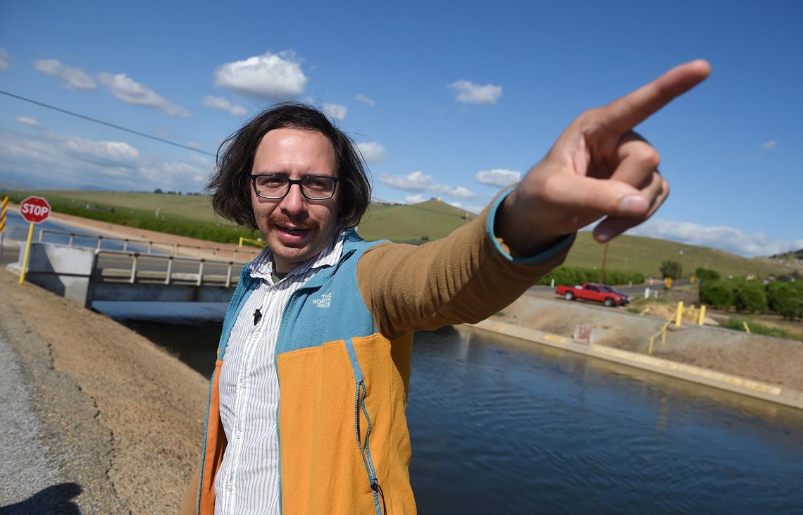 Pedro Hernandez, policy advocate for Leadership Council for Justice and Accountability, points to the far distance as water flows past him on Friday, April 12, 2019 near Tooleville, CA. Hernandez is fighing for Tooleville citizens’ right to clean water and finds it ironic a source of fresh water flows within yards of Tooleville homes, barred by fencing.