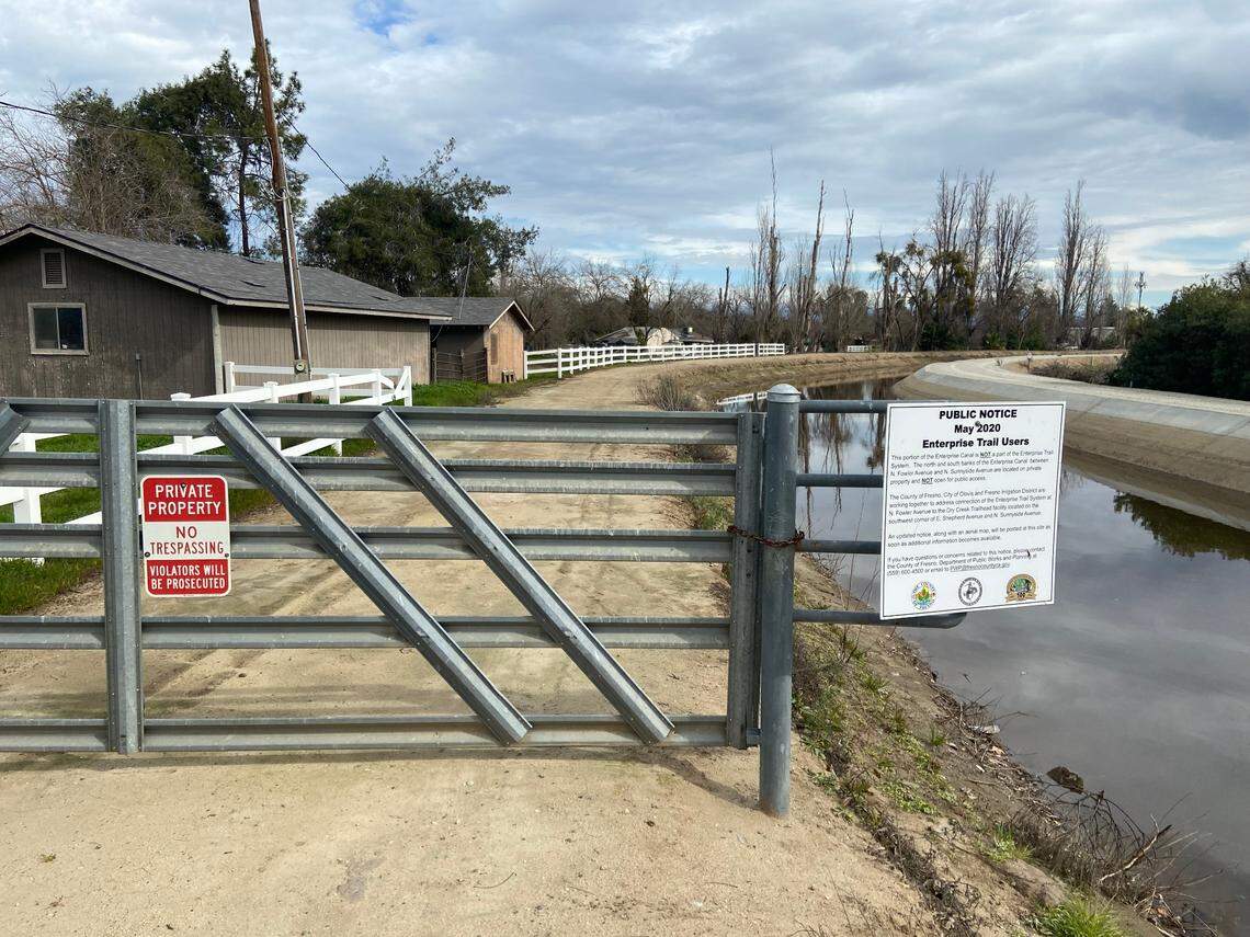 A gate and two warning signs bar the public from using the canal bank to go between the Dry Creek and Enterprise bike trails in north Clovis. Cyclists, runners and walkers have been prohibited since May 2020.