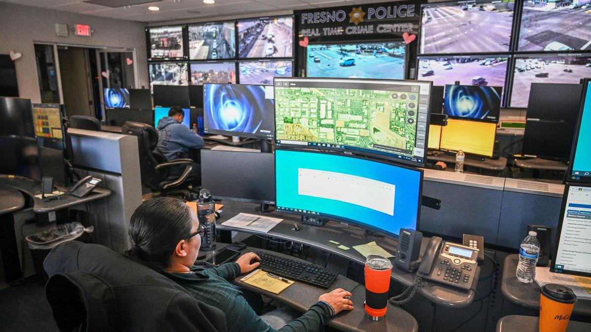 Officers monitor maps, street video cameras and police officer calls inside the Fresno police department’s real time crime center at police headquarters on Monday, Feb. 10, 2025. The department began using artificial intelligence to write some of their reports in the past year.